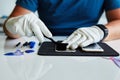 Mechanic cleaning broken cell phone behind desk Royalty Free Stock Photo