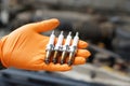 Close up mechanic hands hold old spark plug, spare part of car engine. Royalty Free Stock Photo