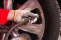 Close up of mechanic`s hand checking the air pressure of a tyre Royalty Free Stock Photo