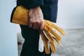 Close-Up of Mechanic Technician Hand is Holding Leather Gloves While Standing in front of Maintenance Workshop, Technical Service Royalty Free Stock Photo