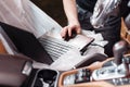 Close-up of mechanic using digital laptop while examining car engine in garage. connect the sensor connector to the car Royalty Free Stock Photo