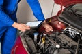 Mechanic Using Digital Tablet While Examining Car Engine