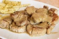 A close up of medallions bathed in a sauce of Cabrales with meat juice with baked potatoes with thyme in the background blurred. Royalty Free Stock Photo