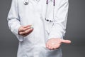 Close-up of medic hands with pills or tablets isolated on gray background