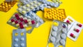 Close up of medical blister packs with tablets on yellow background. Packs with various tablets. Concept of threat of