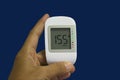 Close up medical device,digital handheld blood sugar detector isolated on blue background. Royalty Free Stock Photo