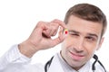 Close up of medical doctor holding small yellow-red pill Royalty Free Stock Photo