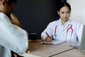 Close up medical doctor in white uniform gown coat interview and filling up an application form while consulting patient, medical