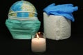 Close-up - a candle of remembrance against the background of a globe, rubber gloves and toilet paper