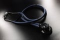 Medical stethoscope placed on dark surface, tool for patient diagnostic