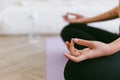 Close up of meditation hand of sporty Asian woman practicing yoga on yoga mat, doing Ardha Padmasana exercise. Royalty Free Stock Photo