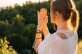 Close-up of meditative young woman sitting in lotus position raising hands in Namaste pose. B