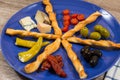 close up of mediterranean antipasti plate with two kinds of olives tomatoes cheese filled peppers separated by breadsticks Royalty Free Stock Photo