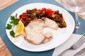 Close up of mediterranean shark steak on white plate on blue tablecloth