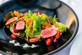 Close-up Medium Rare Tuna Salad Green Coral, Red Coral, Tomato and Salmon Roe with Touched Sea Urchin in black plate