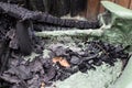 Close-up of a melted green plastic wheelie bin after fire