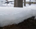 Close Up of Melting Snow Against Glass with Houses in the Background