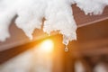 Close-up of melting snow icicles on roof. Falling water drops. Beginning of spring. Meeting cold and heat concept. Fresh spring na