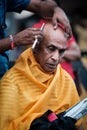 Close-up of men devotee getting tonsured or head shaving ritual in Thaipusam Festival.