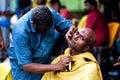 Close-up of men devotee getting tonsured or head shaving ritual in Thaipusam Festival