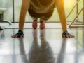 Close up men hand doing push up exercise in the gym in morning sunlight effect. Weight loss, slim body, healthy lifestyle concept