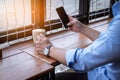 Close up of men hands holding touching mobile phone with blank copy space for your text message on wood in the cafe with light Sun Royalty Free Stock Photo