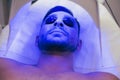 Face of a calm young man lying in tanning bed in solarium Royalty Free Stock Photo