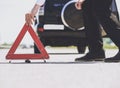 Close Up. Men Put Red Warning Triangle with Car. Royalty Free Stock Photo