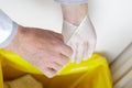 Close-up man removing latex gloves from hands into dustbin Royalty Free Stock Photo