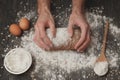 Close-up of men`s baker hands on black bread with flour powder. Baking and patisserie concept Royalty Free Stock Photo