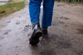 Back view of a boots covered in mud taken while walking after rain. Royalty Free Stock Photo