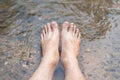 Close up Men`s feet are soaked in streams river