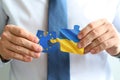 Close-up Of Men`s Hand Connecting Jigsaw Puzzle. Ukraine is joining European Union