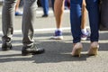 Close up of men and women legs in different shoes, high heels walking fast along the concrete road on bright sunny day. Busy lifes Royalty Free Stock Photo