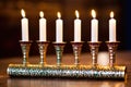 a close-up of a menorah with yarmulkes and a torah scroll visible