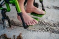 Close-up of mens feet on wheelchair, on beach. Royalty Free Stock Photo