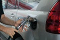 Close-up of a mens hand refilling the car with a gas pump. Man inserting nozzle in fuel cap of a car Royalty Free Stock Photo