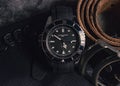 Close-up of a men\'s watch and leather belt.