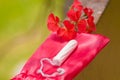 Close up of a a menstruation cotton tampon over a red cotton bag, with a beautiful red flower, in a blurred background Royalty Free Stock Photo