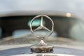 Close up of a Mercedes Benz logo on the hood of a car
