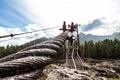 Close-up on a metal binding cable going in perspective to the bridge support with the texture of a summer sunny day. Reliability