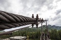 Close-up on a metal binding cable going in perspective to the bridge support with the texture of a summer sunny day. Reliability