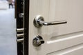 Closeup of metal doorhandle and look on white door Royalty Free Stock Photo