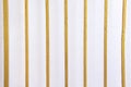 Metal fence with gold paint on old white concrete wall background Royalty Free Stock Photo