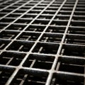 Close-up of a metal grid with a lattice pattern. The grid is composed of intersecting square bars, Royalty Free Stock Photo