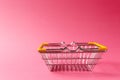 Close up of metal grocery basket for shopping in supermarket with lowered handles and yellow plastic elements isolated