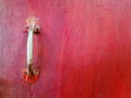 Close up metal handle of door or window on the red wooden background painted with copy space Royalty Free Stock Photo