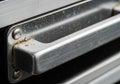 Close-up of a metal handle on a drawer or door. The rectangular handle is secured with two screws Royalty Free Stock Photo