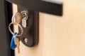 Close-up of metal keys and key chain in the door lock of the house and office. Security concept against hacking of apartments and