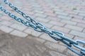 Close-up of a metal long stretched chain over the sidewalk Royalty Free Stock Photo